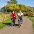 Senior man and woman on bicycles on a dutch countryroad