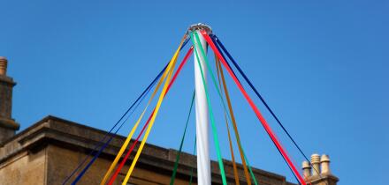 Colourful ribbons of maypole in front of cotswold stone building, Chipping Campden, Gloucestershire, England, United Kingdom, Europe