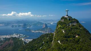 Christ the Redeemer statue atop Corcovado, and Sugarloaf Mountain, Rio de Janeiro, Brazil, South America - aerial