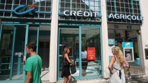 People walk outside a branch of Credit Agricole Bank, in Nice, southeastern France, Wednesday, Sept. 14, 2011. Moody's on Wednesday downgraded the credit ratings of French banks Societe Generale and Credit Agricole following a period of huge volatility in