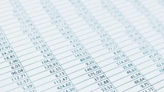 Business data report selective focus close up. Monthly stock stats spreadsheet. Blue toned.