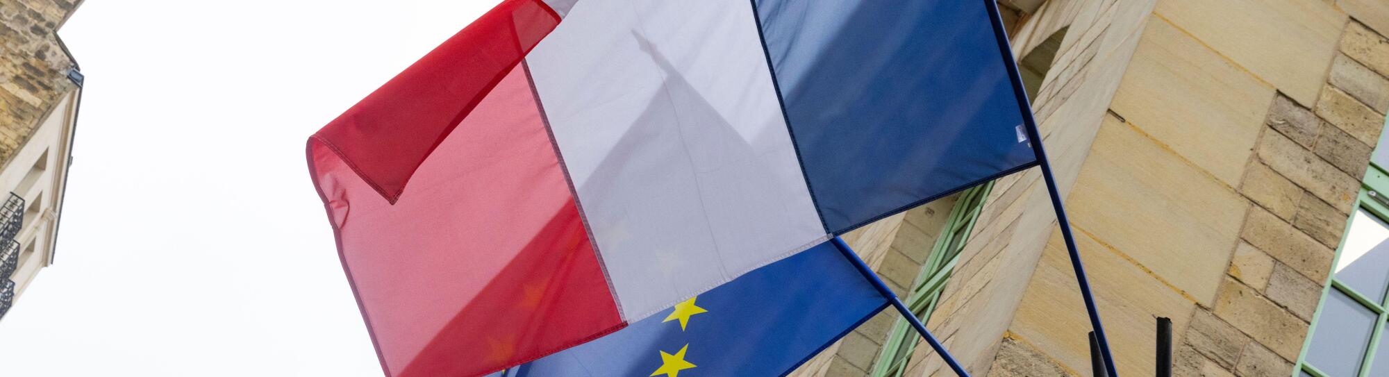 The flag of France in front of European Union flag in Paris, France