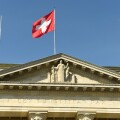 Swiss flag and statue of Justice on Federal Supreme Court of Switzerland. Lausanne, Switzerland