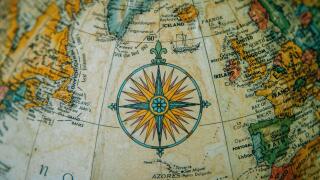 Close-up of a vintage globe showing Europe and the North Atlantic with a detailed compass rose.