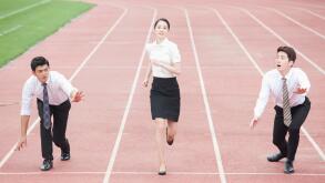 Business people racing on tracks at stadium