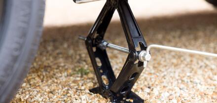 Close up of a car jack underneath a car. Part of a series of photos depicting changing a flat tyre (tire)