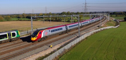 A Virgin Pendolino heads a Glasgow bound service north through Litchfield Trent Vallet while a London Midland stopper heads sout