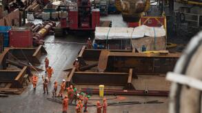 Workers on the deck of the Saipem S7000 heavy lifting vessel, pulling a rope. credit: LEE RAMSDEN / ALAMY