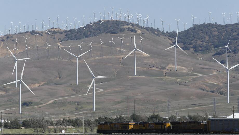 Tehachapi, CA. April 30, 2017. A cargo train passes beneath windmills in the Tehachapi Wind Resource Area, California's largest wind energy farm.