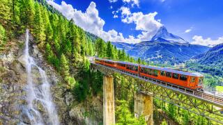 Zermatt, Switzerland. Gornergrat tourist train with waterfall, bridge and Matterhorn. Valais region.