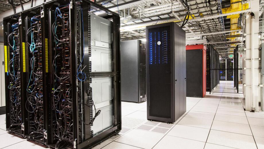 Racks of servers aligned in rows in a large computer server farm.