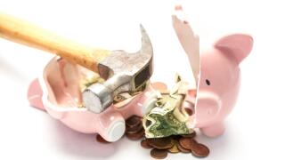 Piggy bank broken with money and hammer on white background