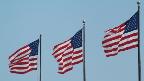 Stars and Stripes flags flying on three flagpoles United States of America USA