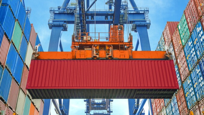 Shore crane loading containers in freight ship