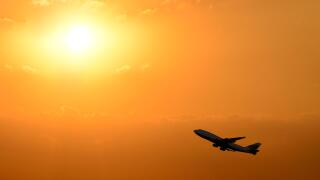 Airplane Taking Off Silhouetted Against a Sunset.