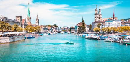 Panoramic view of Zurich city center with churches and boats on beautiful river Limmat in summer, Canton of Zurich, Switzerland