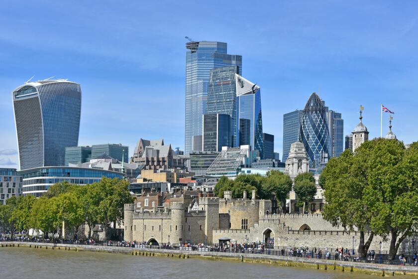 Riverside busy with tourists at Tower of London & view of 2019 London city skyline cityscape with landmark skyscrapers business buildings England UK