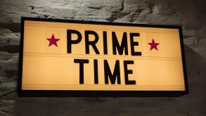 Close-up of Prime Time signboard against gray wall