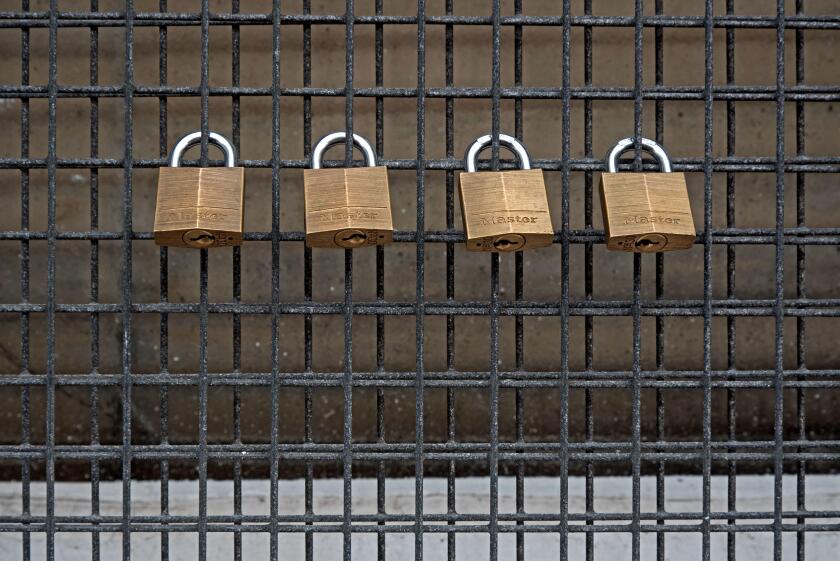 Four Master padlocks on a grill.