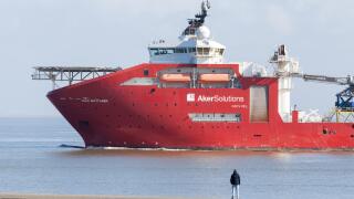 A man watching a Norwegian Deepwater Subsea Equipment Support Vessel (SESV), Aker Wayfarer, depart Eemshaven in the Netherlands