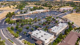 Drone images over a shopping center in Antioch, California. With cars in the parking lot and street lights