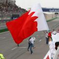 A marshal celebrates waving Bahrain flag after the Bahrain Formula One Grand Prix at the Formula One Bahrain International Circuit in Sakhir, Bahrain, Sunday, April 22, 2012. (AP Photo/Luca Bruno)