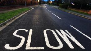 A slow down sign painted on a city road