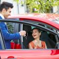 Salesman giving keys to an attractive womans new car