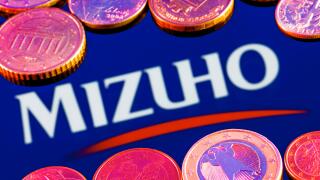 Variety of metal coins on background of Mizuho Financial Group logo