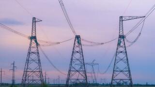 Industrial background group silhouette of transmission towers or power tower, electricity pylon, steel lattice tower at purplr sunset. Texture of high