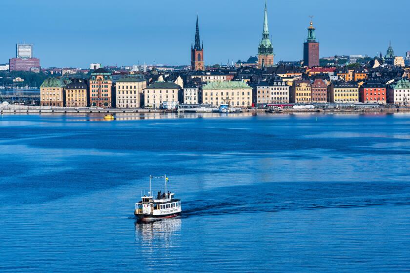 Early morning view of Stockholm waterfront building on Stadsholmen island with Stockholm ferry in foreground, Stockholm, Sweden, Northern Europe
