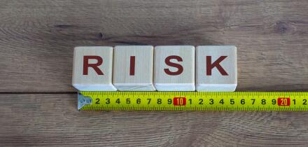 Risk Word On Blocks Arranged Behind The Ruler On Wooden Table