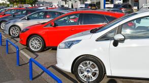 Ford car dealership business edge of pavement forecourt display of row of second hand used cars for sale dealer name removed Essex England UK