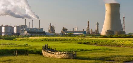 A chemical plant on the bank of the Humber estuary with derelict boat beached in the mud bank.