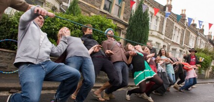 Limbo dance with a hose pipe, during a street party, Bristol.