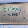 The inscription Clean me on a dirty car with a smile.