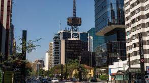 Itau Cultural building with his iconic communication tower on top surrounded by many commercial buildings and office complexes at Paulista Avenue.