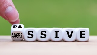 Hand turns a dice and changes the word "passive" to "aggressive", or vice versa.