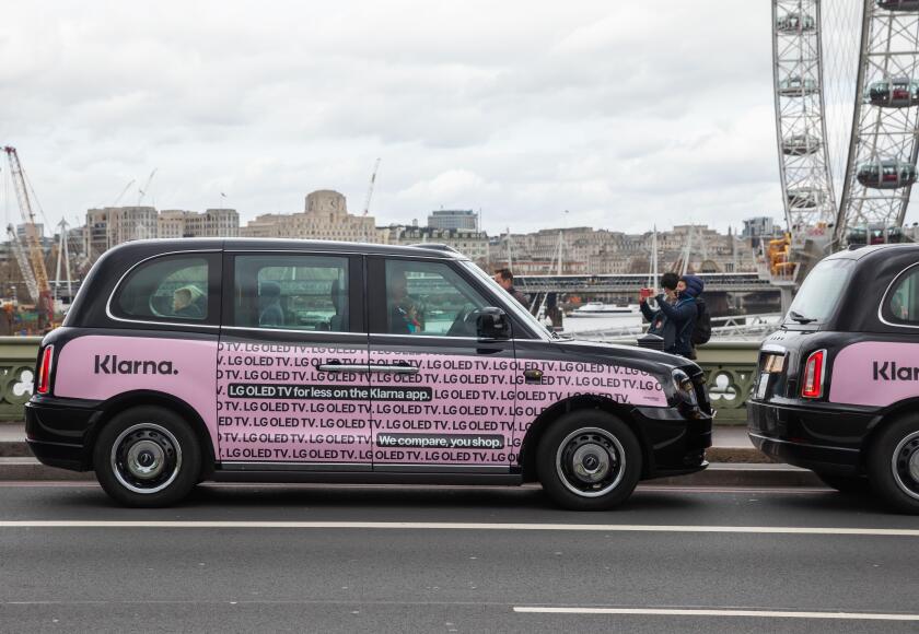 Black taxis with pink Klarna poster in Westminster London, UK