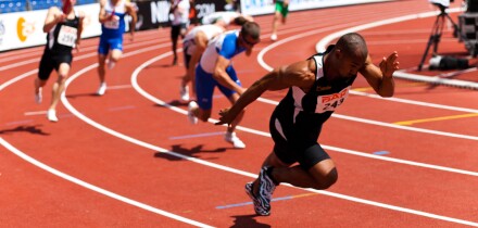 High resolution image of some sprinters starting to take the baton at athletics event.