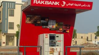 "Ras al Khaimah, RAK/ United Arab Emirates - 10/10/2019: RAK Bank red logo atm sign in evening on a main road in the northern Emriates"