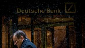 A man walks past the Deutsche Bank offices during a snow storm in Manhattan's financial district in New York January 21, 2014.   REUTERS/Brendan McDermid/File Photo