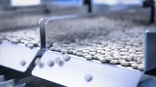 Close up of tablets in packing machine in pharmaceutical factory