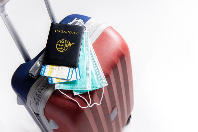 Travel suitcase / luggage, passport, air ticket and mask. Travel ban during the pandemic of  coronavirus or covid-19