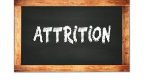 ATTRITION text written on black wooden frame school blackboard.