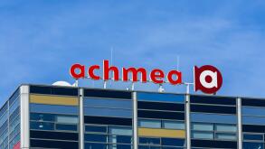 A modern office building featuring the prominent Achmea logo against a clear blue sky. Leiden, Netherlands, 3 May 2025.