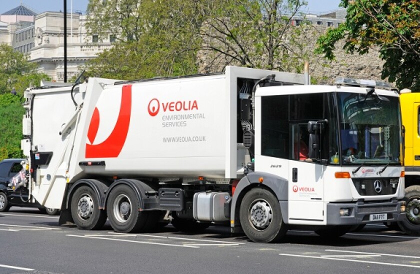 Veolia environmental services dustcart driving along London Street in Tower Hamlets England UK