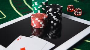 Online poker gambling concept. Chips and poker card on a digital tablet