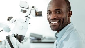 Ordinary workday. African American short-haired beaming doctor openly smiling and showing his ideal white teeth