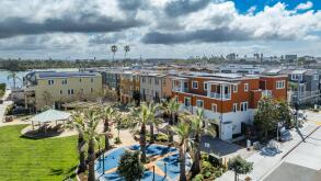 San Diego Mission Beach luxury vacation rental complex with palm trees, playground, covered shade area, single family home with triple garage